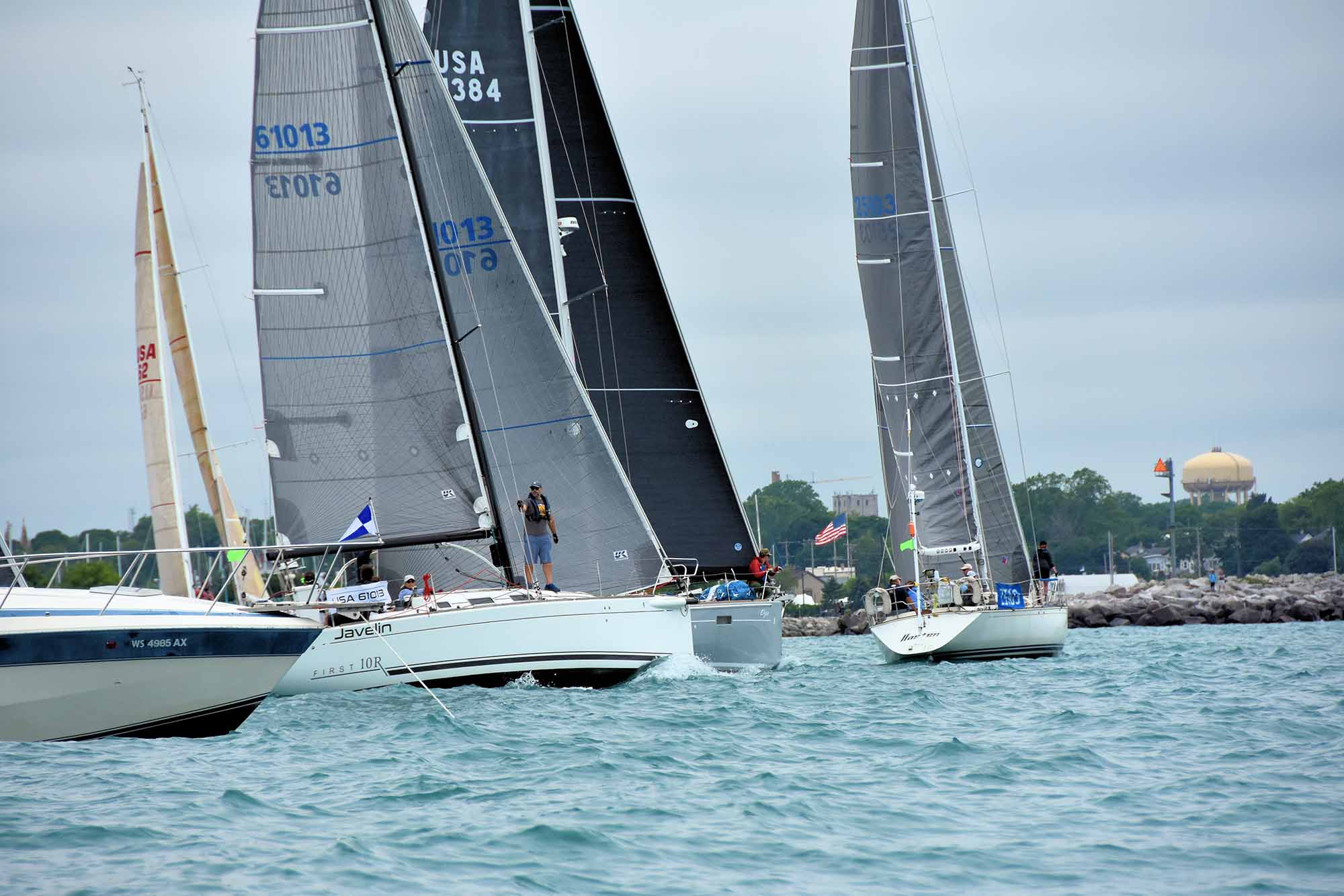 Several yachts in full sail stand close together in the Racine Yacht Club harbor preparing to start the 2022 Hook Race. Photo by Scott Lewis.