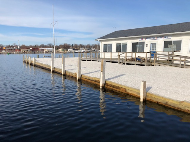 The Ludington Yacht Club in Ludington, Michigan. A white building with a deck outside, bordering a lake