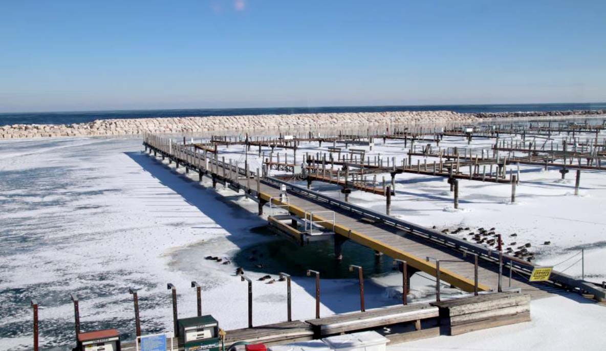 South Shore Yacht Club harbor with breakwater construction in progress, showing a completed level rock barrier in the water.