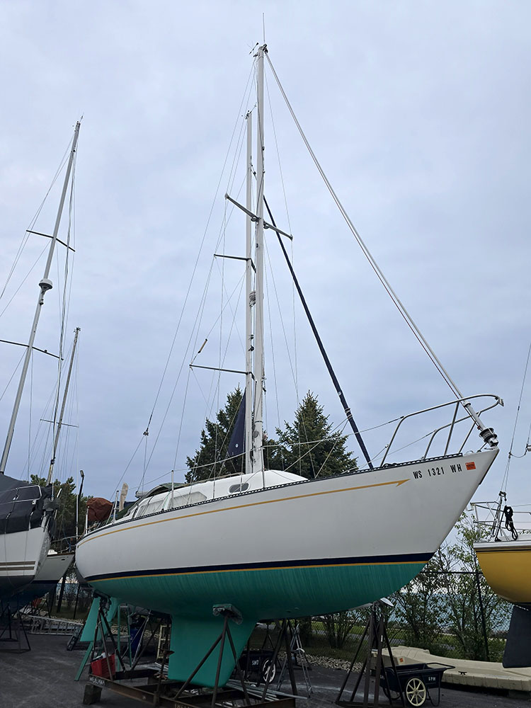 A 30-foot teal and white sailboat named Ripple Effect, on a trailer.